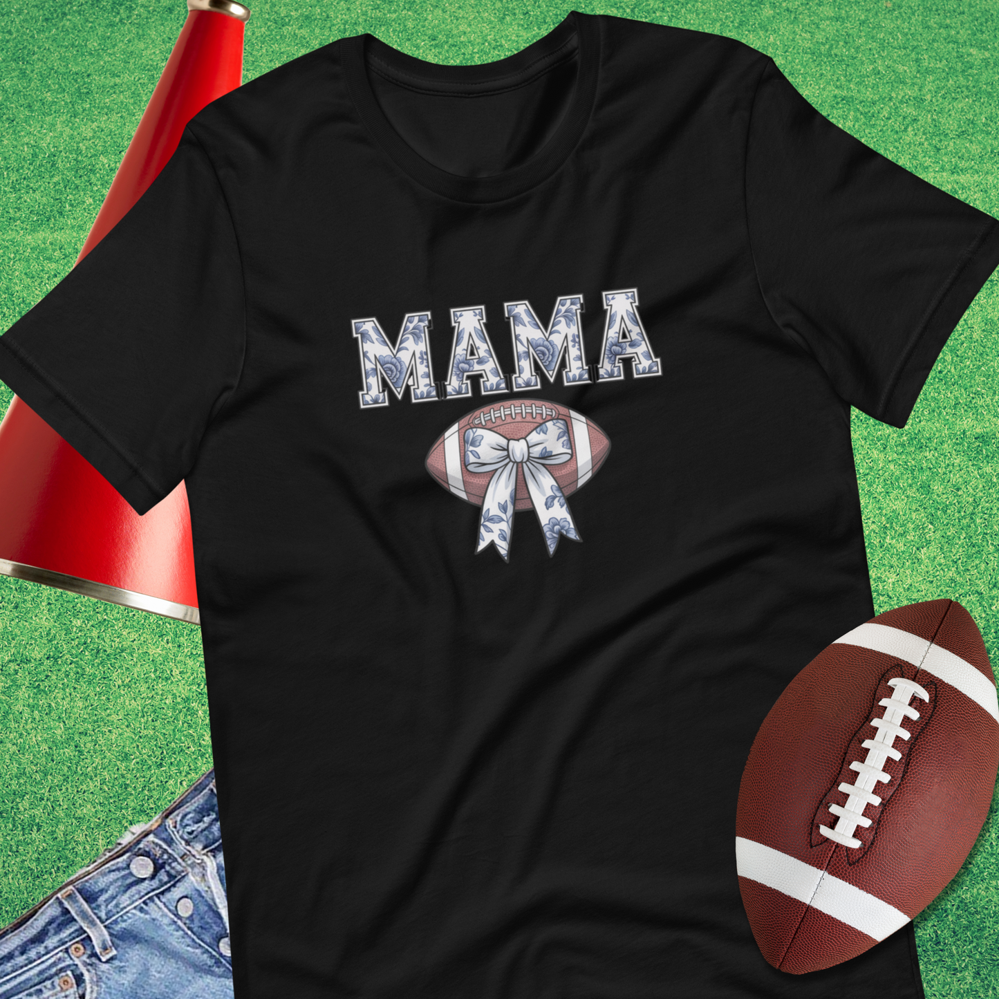 Flat lay of Sideline Gods Mama football graphic tee with floral chinoiserie design and bow detail.