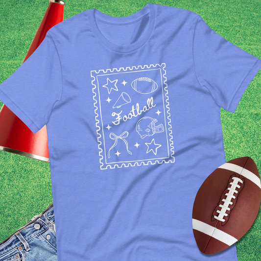 Flat lay of Sideline Gods football doodle tee with helmet and football accessories blue coquette girly trendy